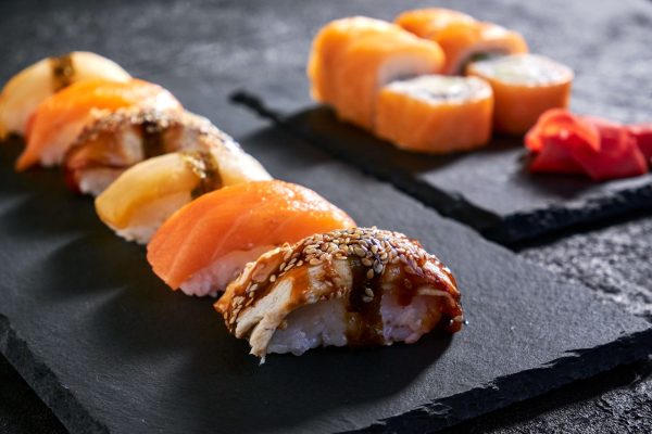 assorted-sushi-with-salmon-eel-escolar-black-stone-plate-dark-background
